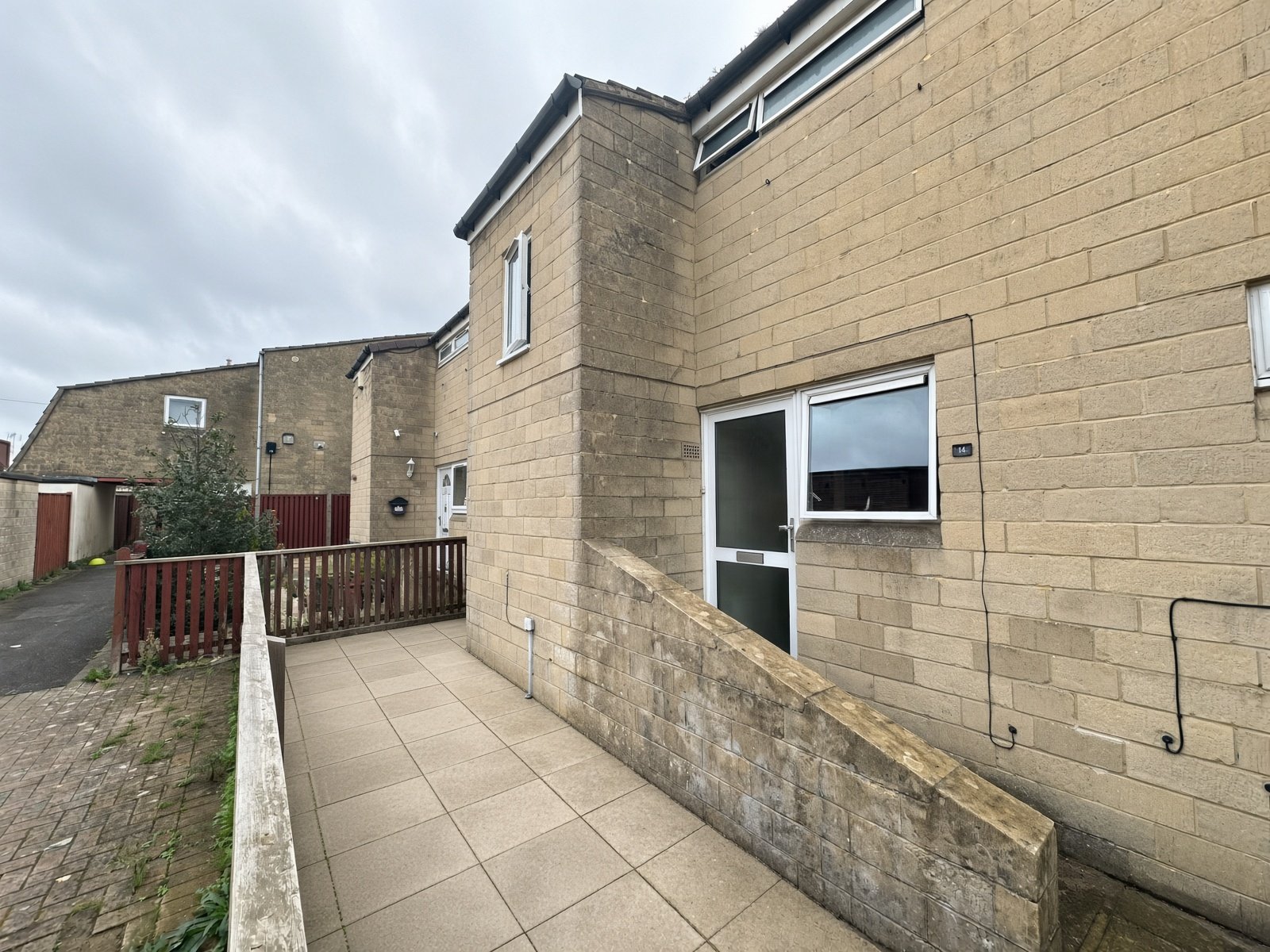 Side of 14 Rooksbridge Walk with paved path and fencing