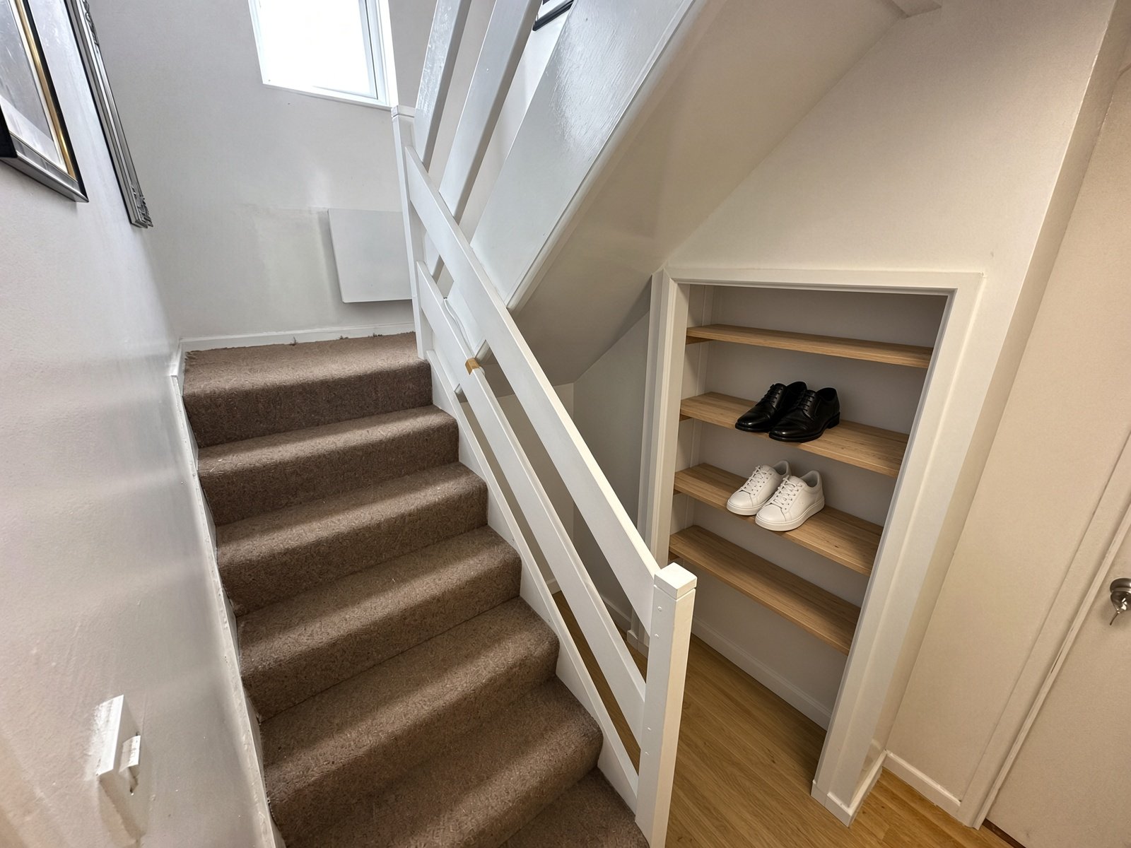 Hallway with carpeted staircase and under-stairs storage