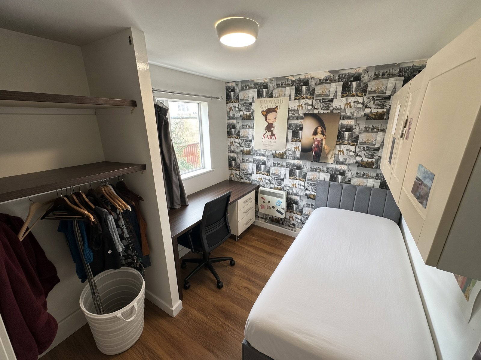 Bedroom with feature wallpaper, desk and hanging rail