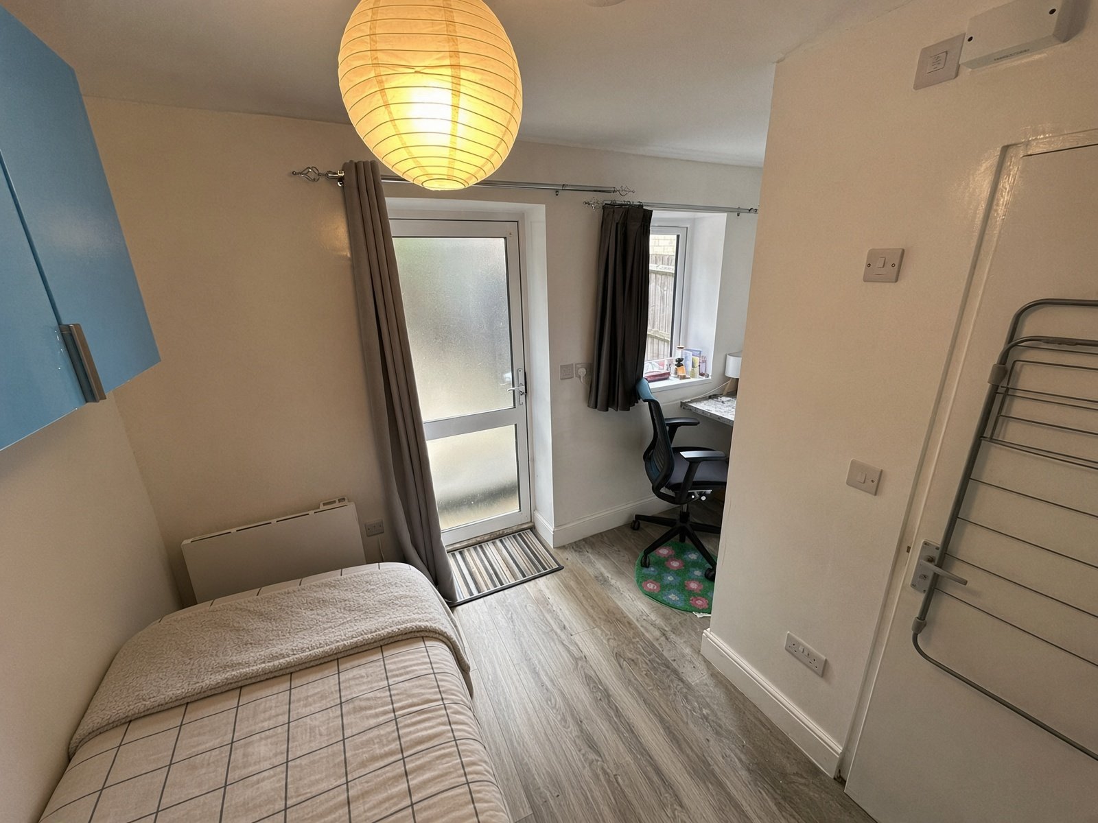 Bedroom with pendant light, bed and glazed garden door