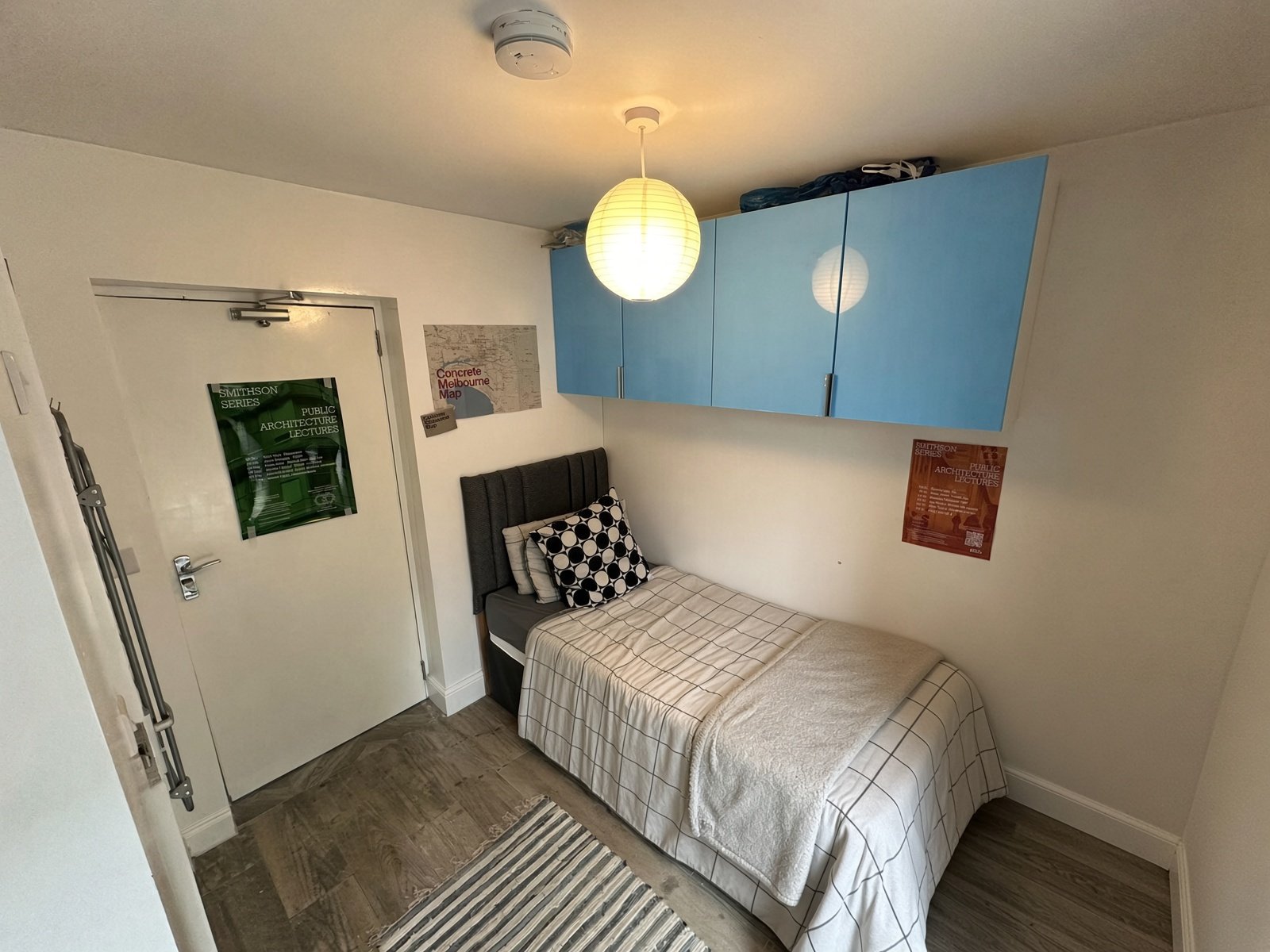 Bedroom with blue overhead cupboards and double bed