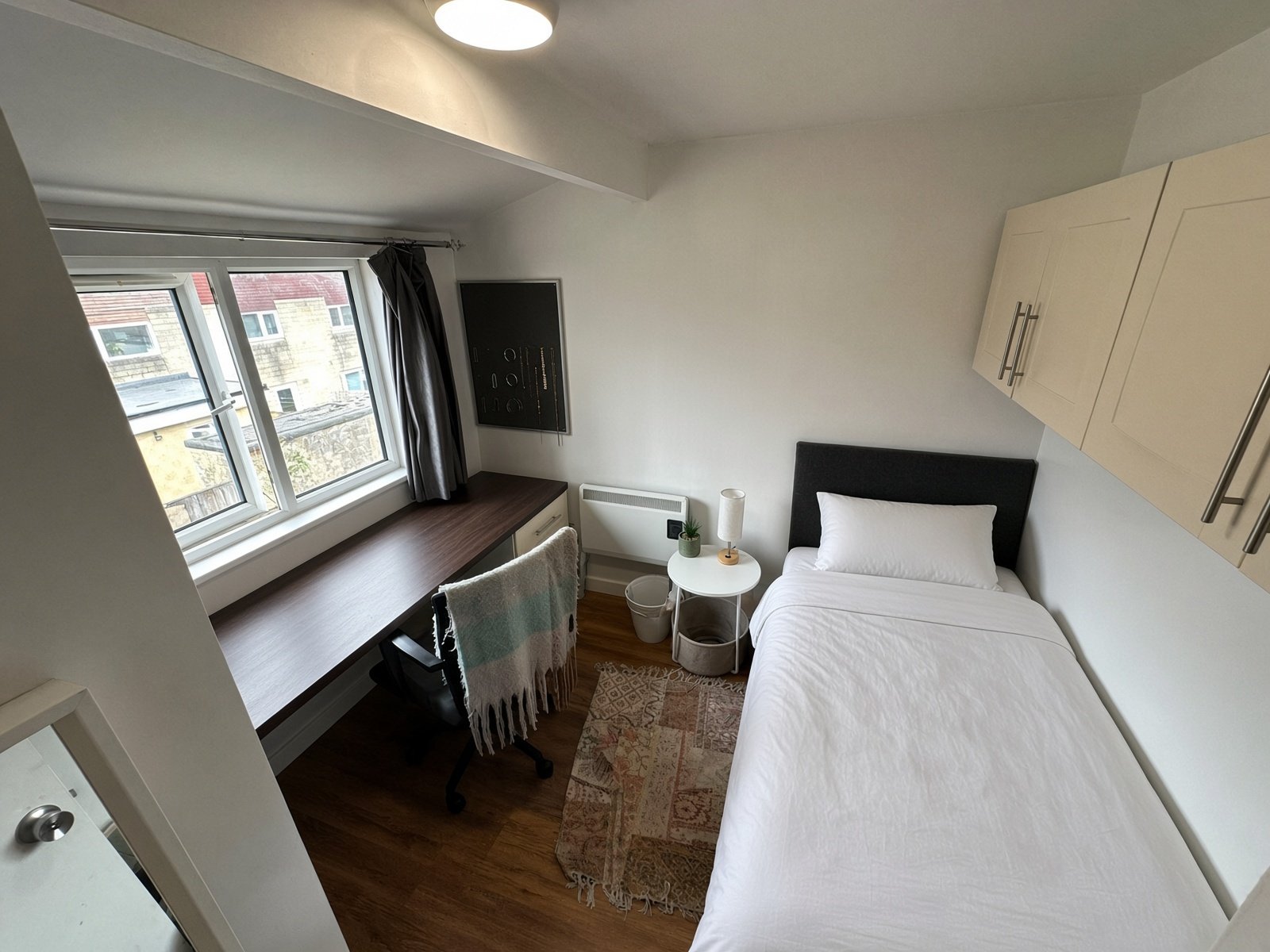 Bedroom with single bed, desk and large window