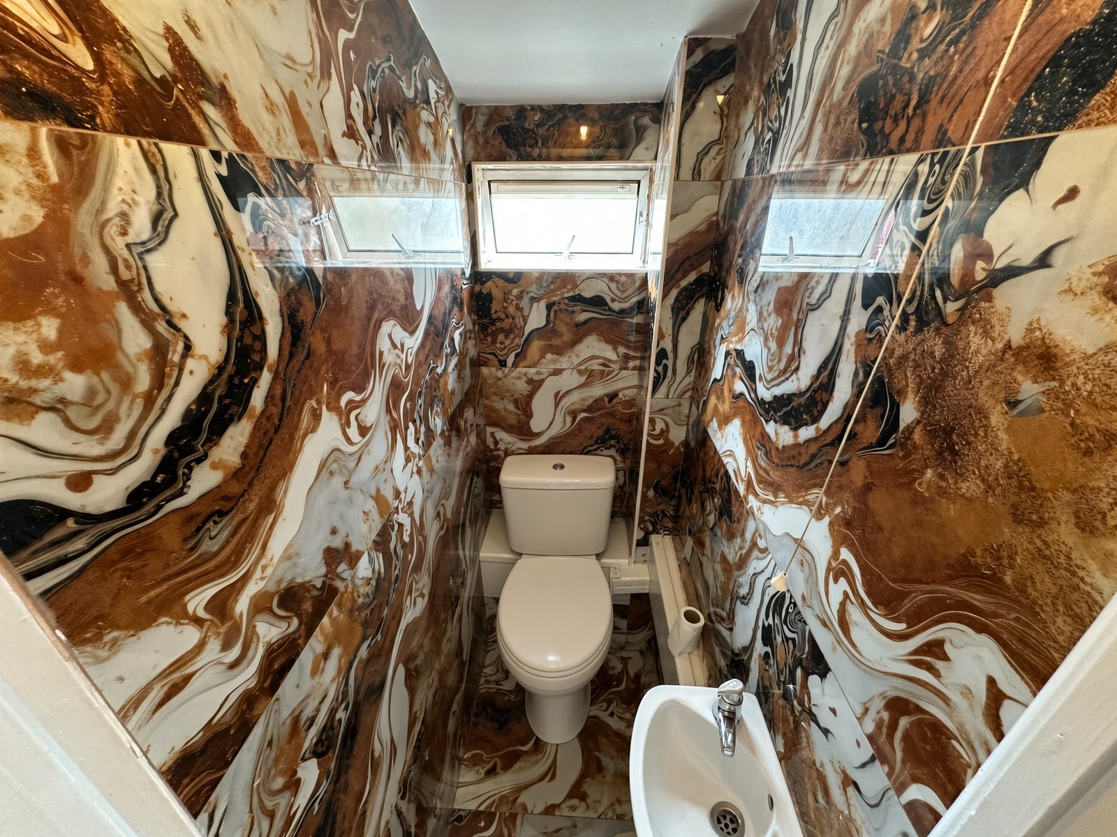WC with bold marble-pattern walls and basin
