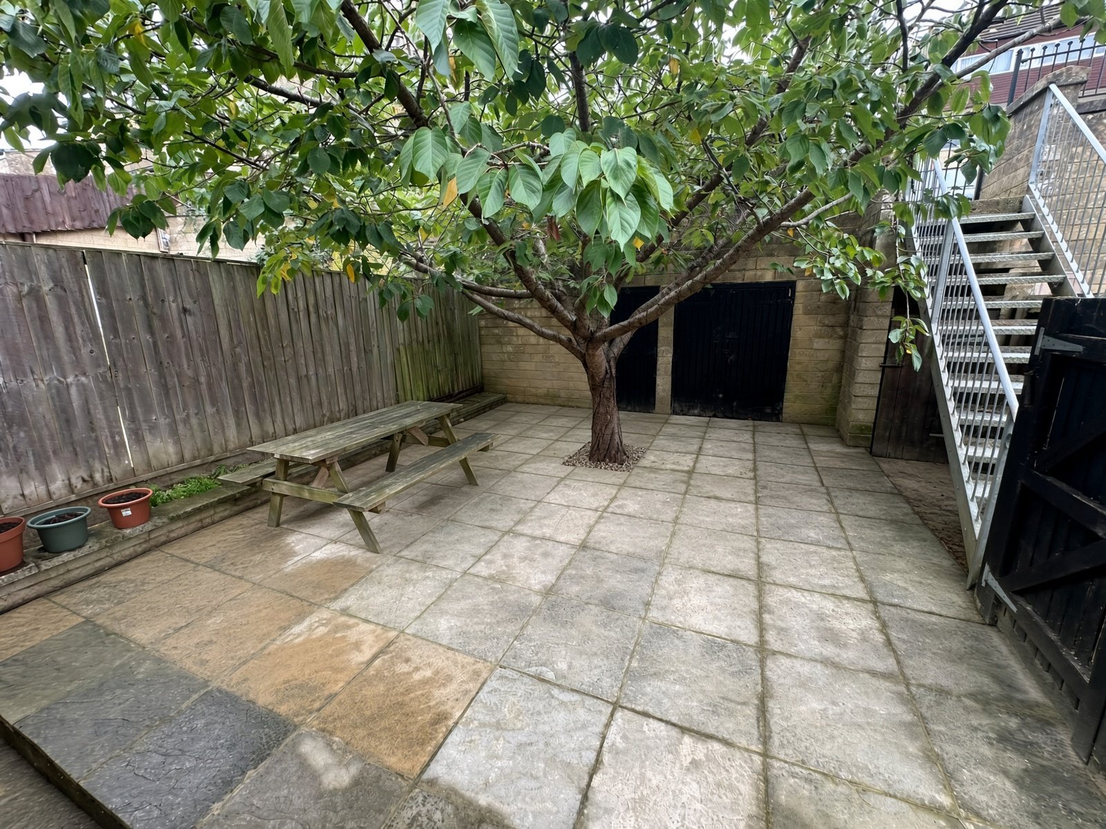 Rear garden patio with mature tree and fencing