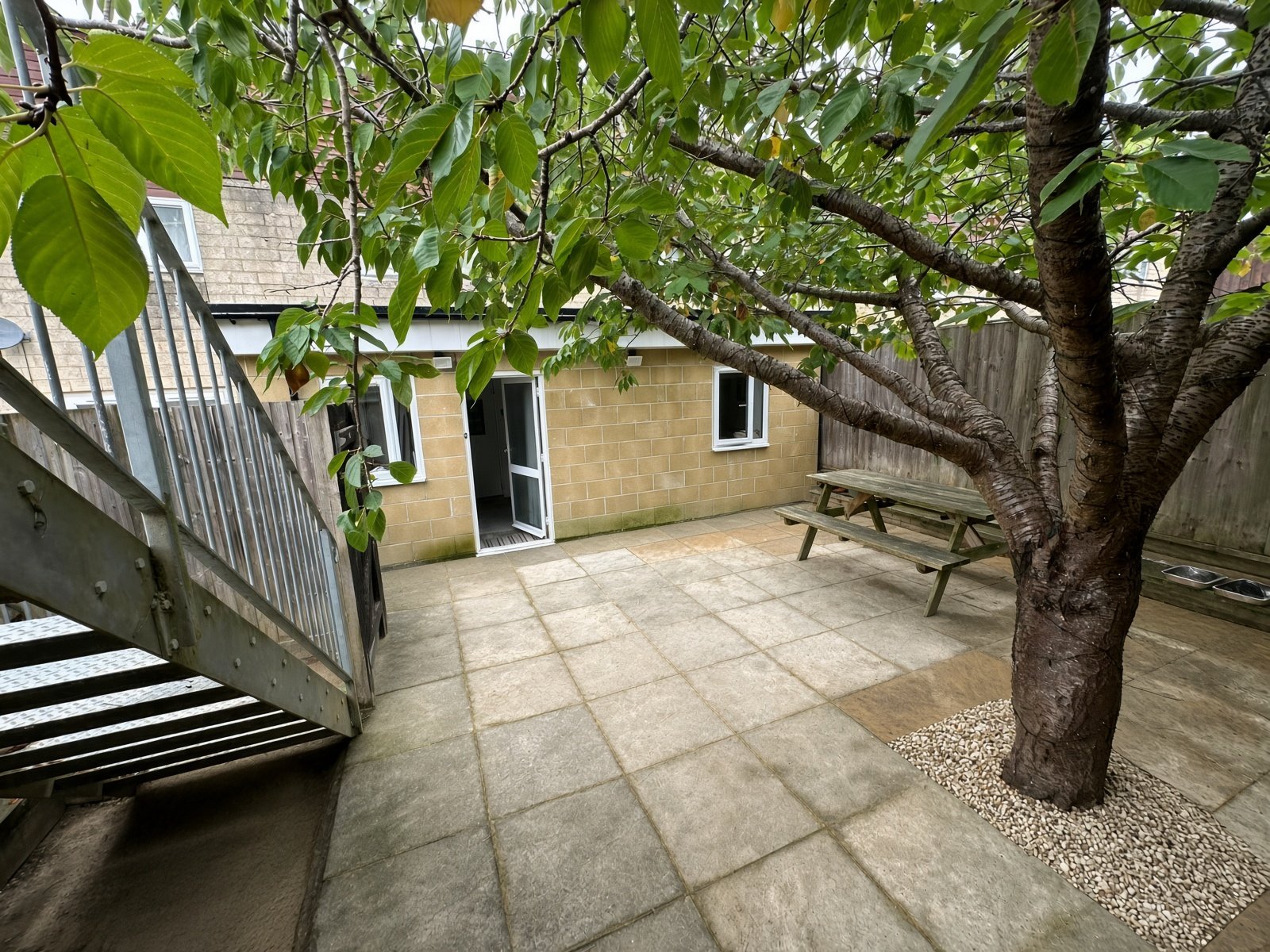 Rear garden with tree, picnic bench and external stairs