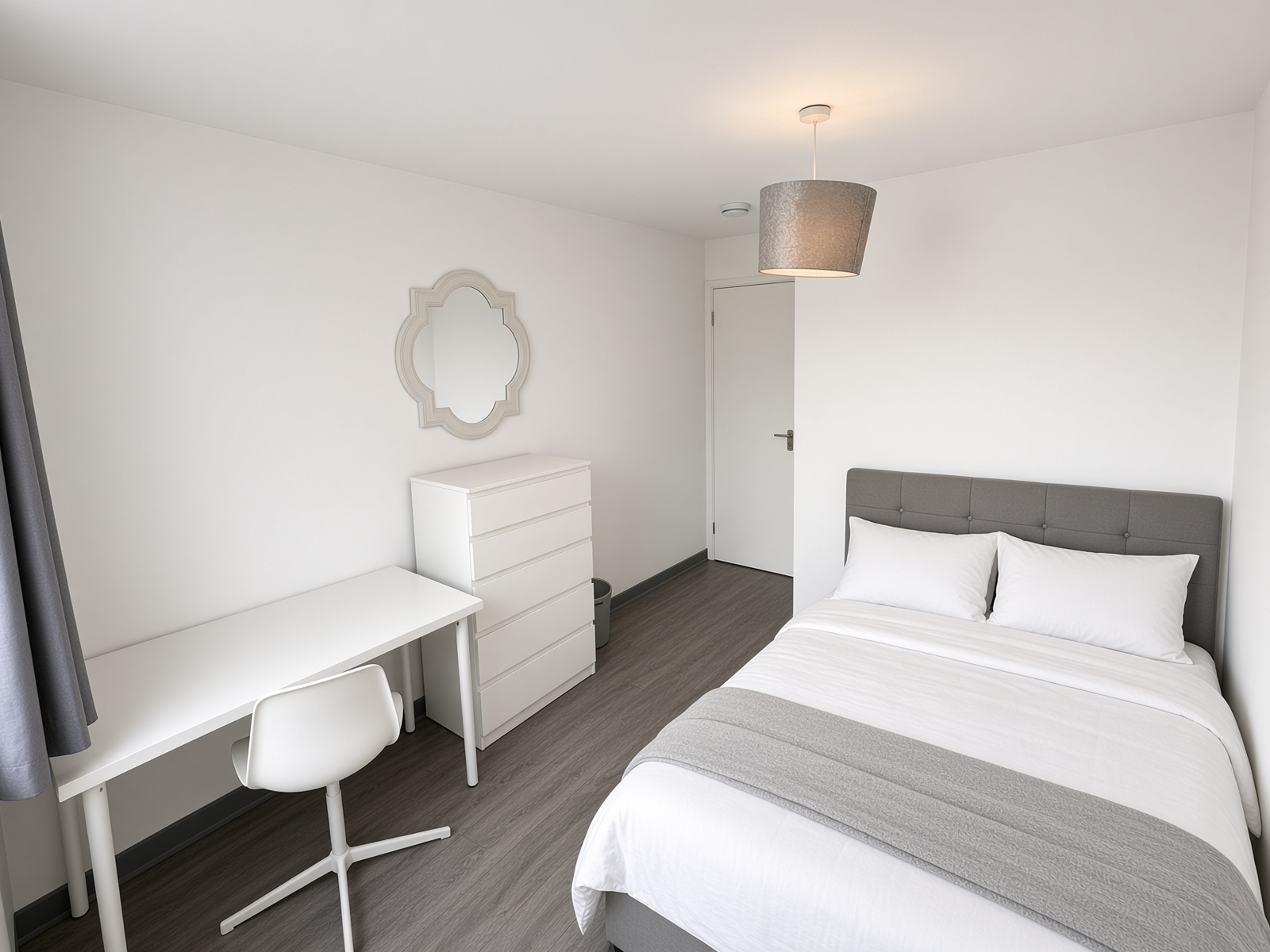 Bedroom with grey headboard, white desk and chair, and tall white drawers