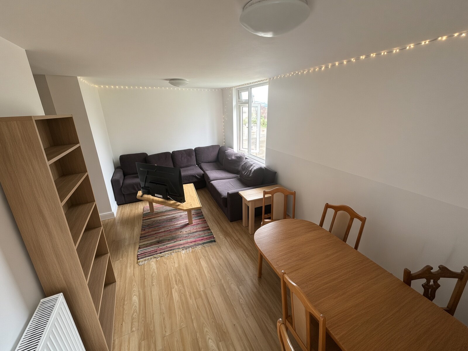 Living room with dark sofas, rug and dining table