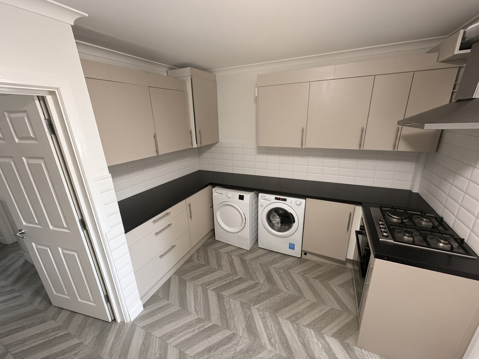 Kitchen with grey units, washing machine and herringbone floor