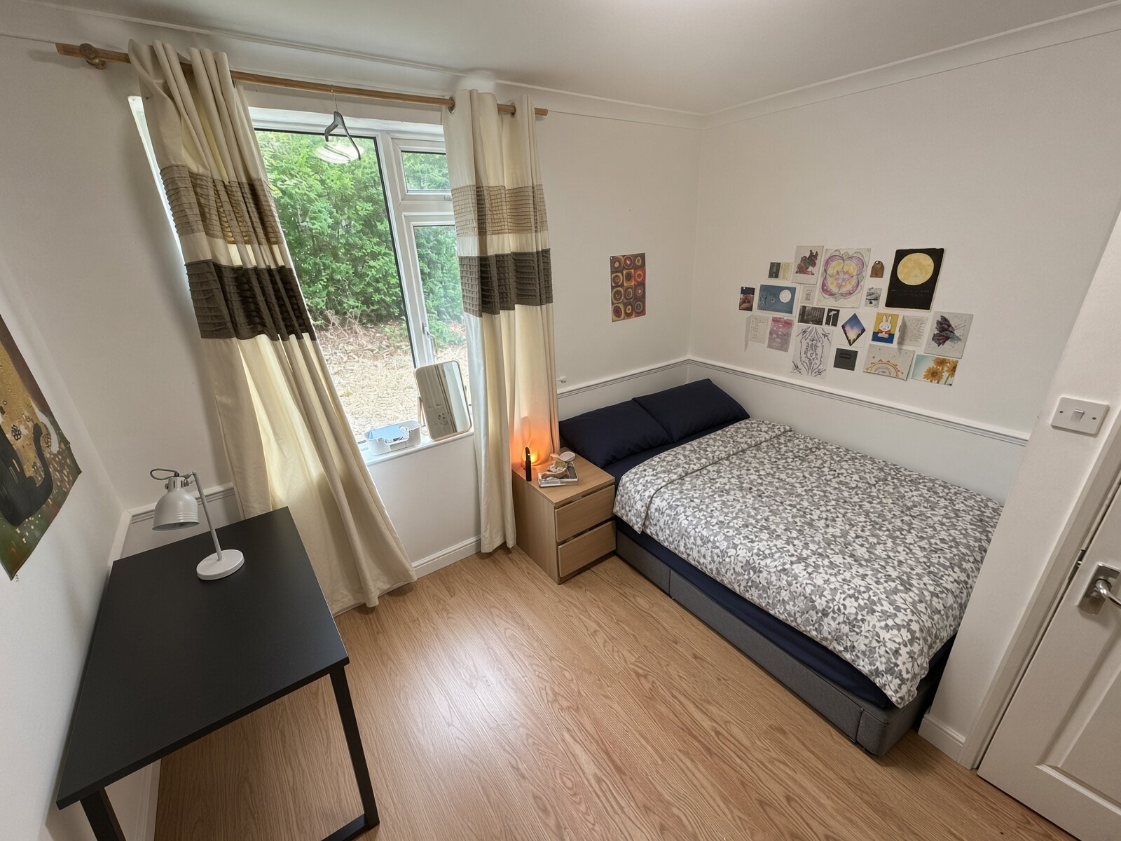 Bedroom with double bed, desk and window with curtains