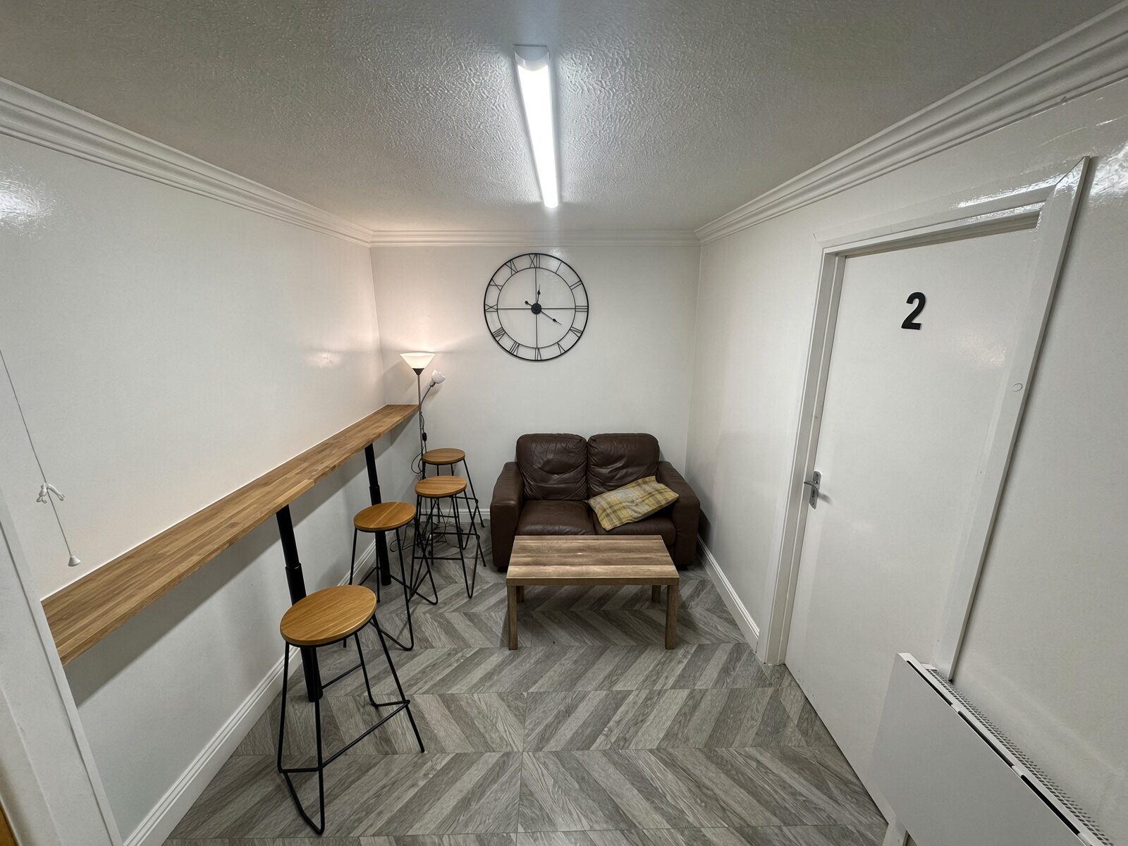 Kitchen and dining area with breakfast bar, stools and sofa