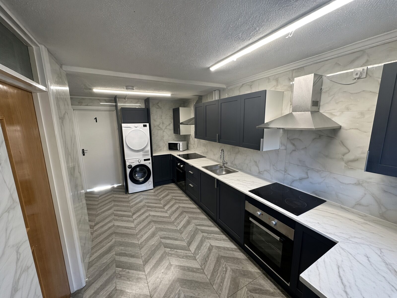 Kitchen with dark units, oven and washing machine