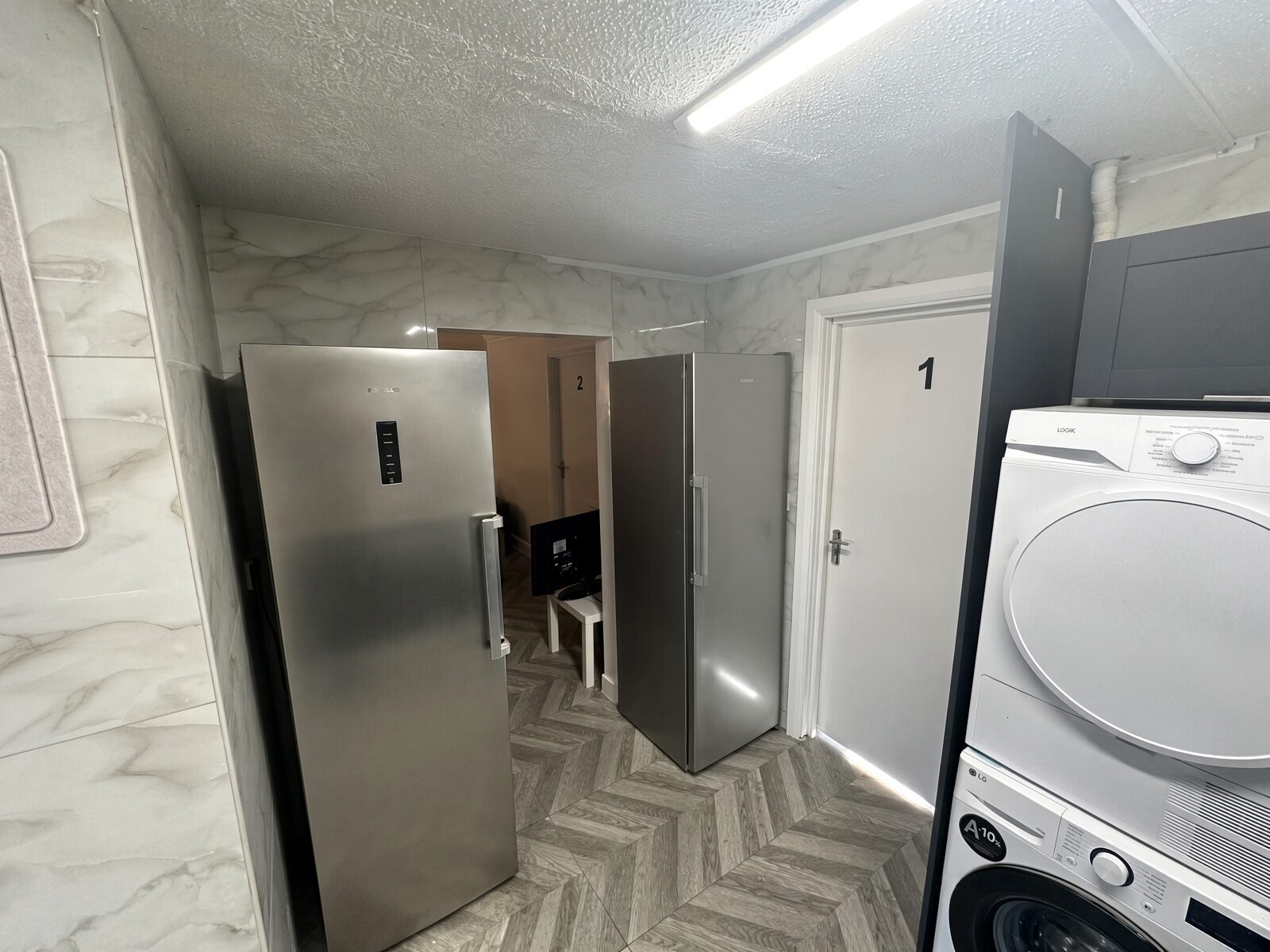 Kitchen with fridge freezer, tumble dryer and herringbone floor