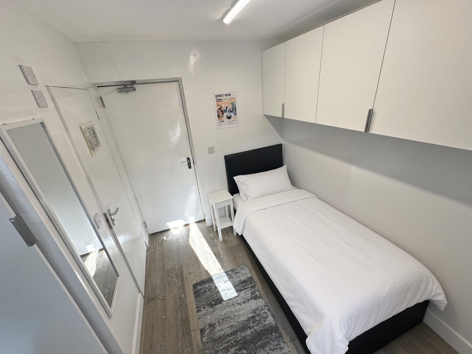 Bedroom with single bed and overhead cupboards