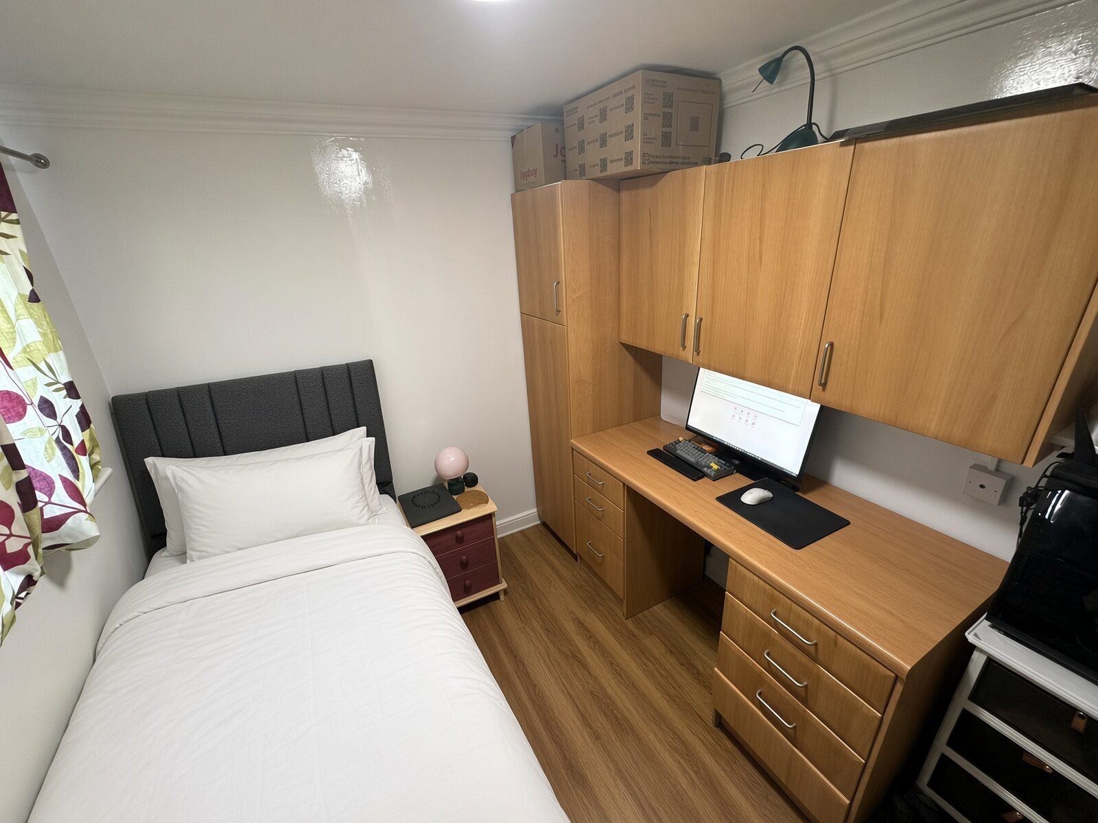 Bedroom with single bed, wood desk and shelving