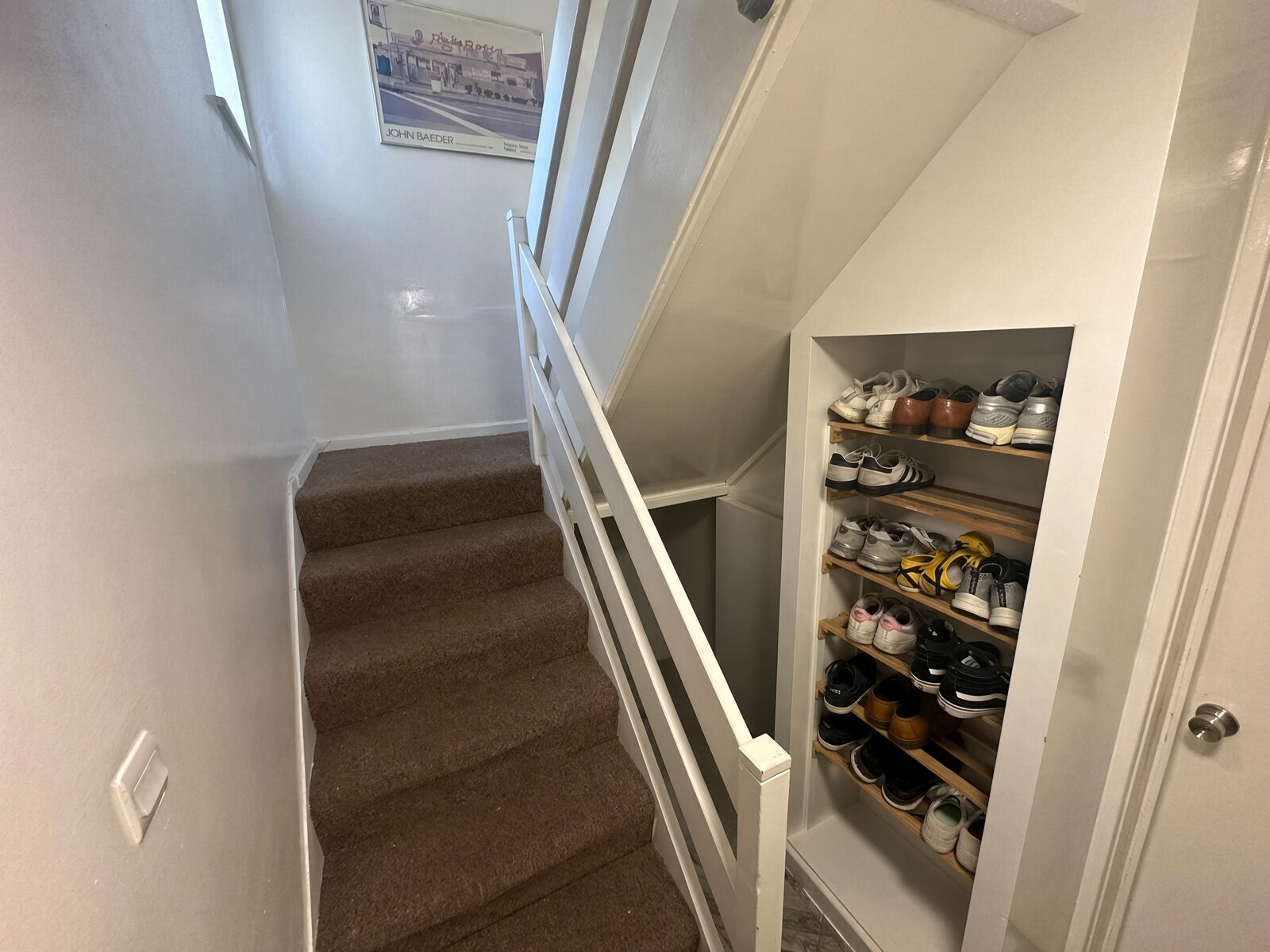 Staircase with wood treads and shelving on the landing