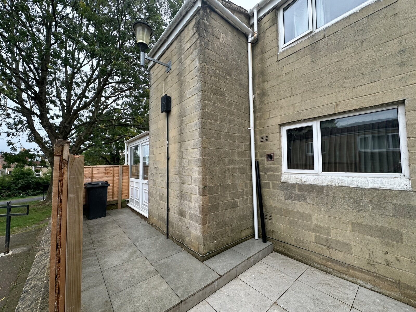 Paved patio and white entrance porch at the side of the house