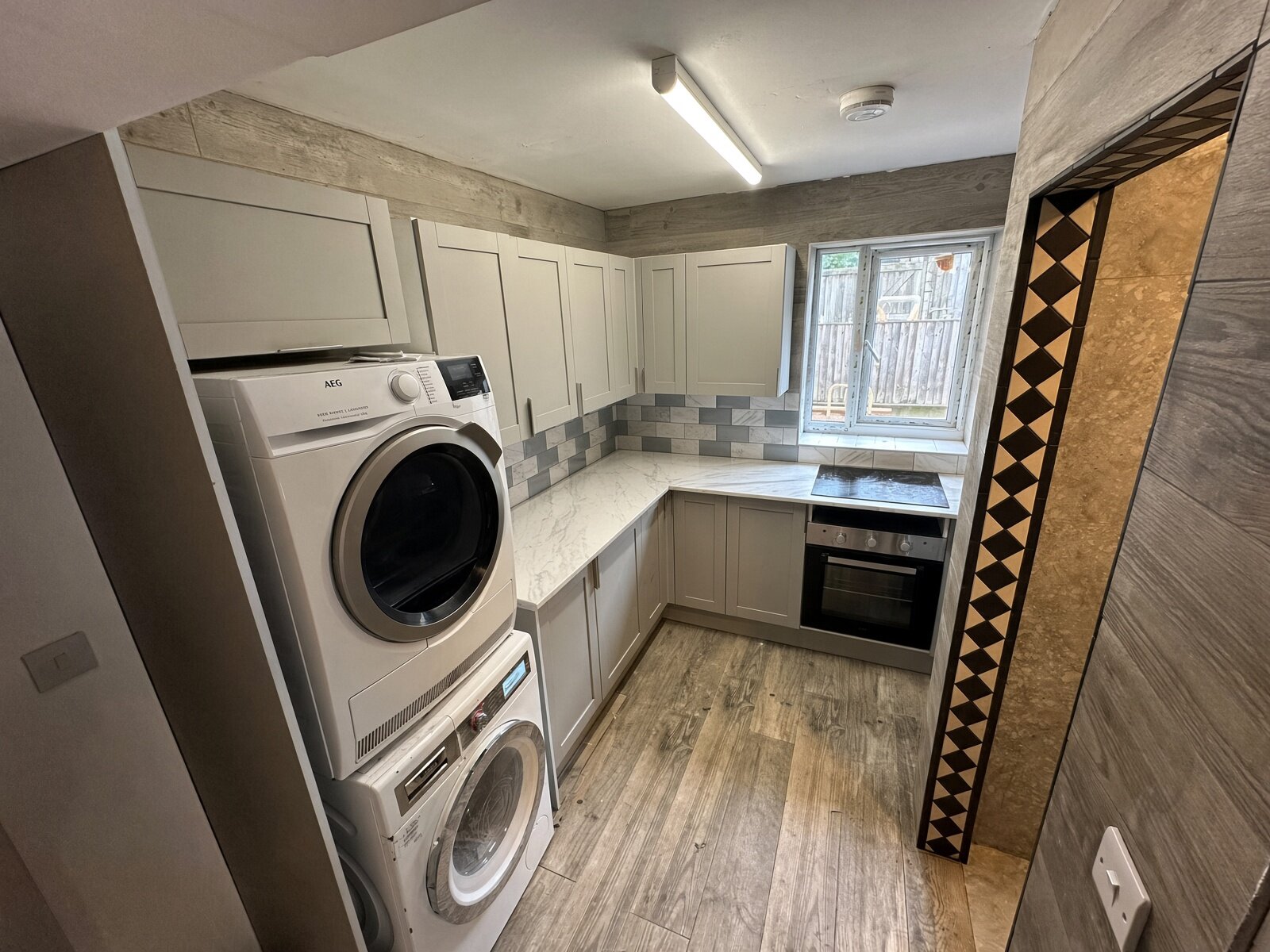 Kitchen with washer and dryer, grey units and window