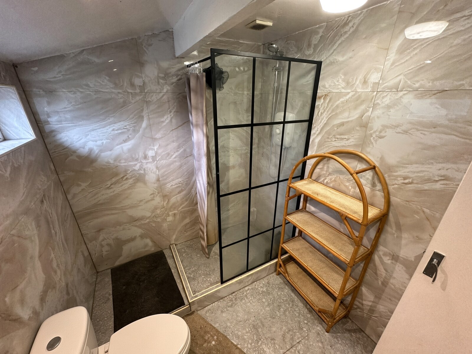 Shower room with black-framed shower screen and marble-effect tiles