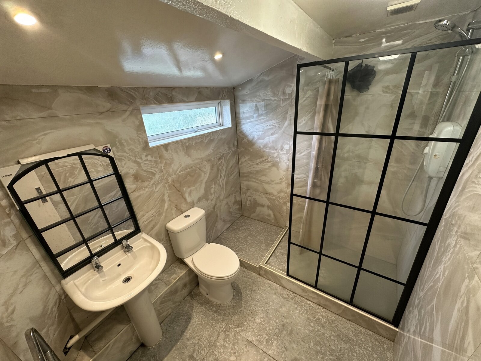 Shower room with black-framed shower screen, basin and WC