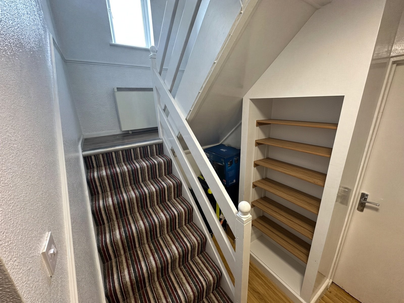 Hallway with carpeted staircase and built-in shelving