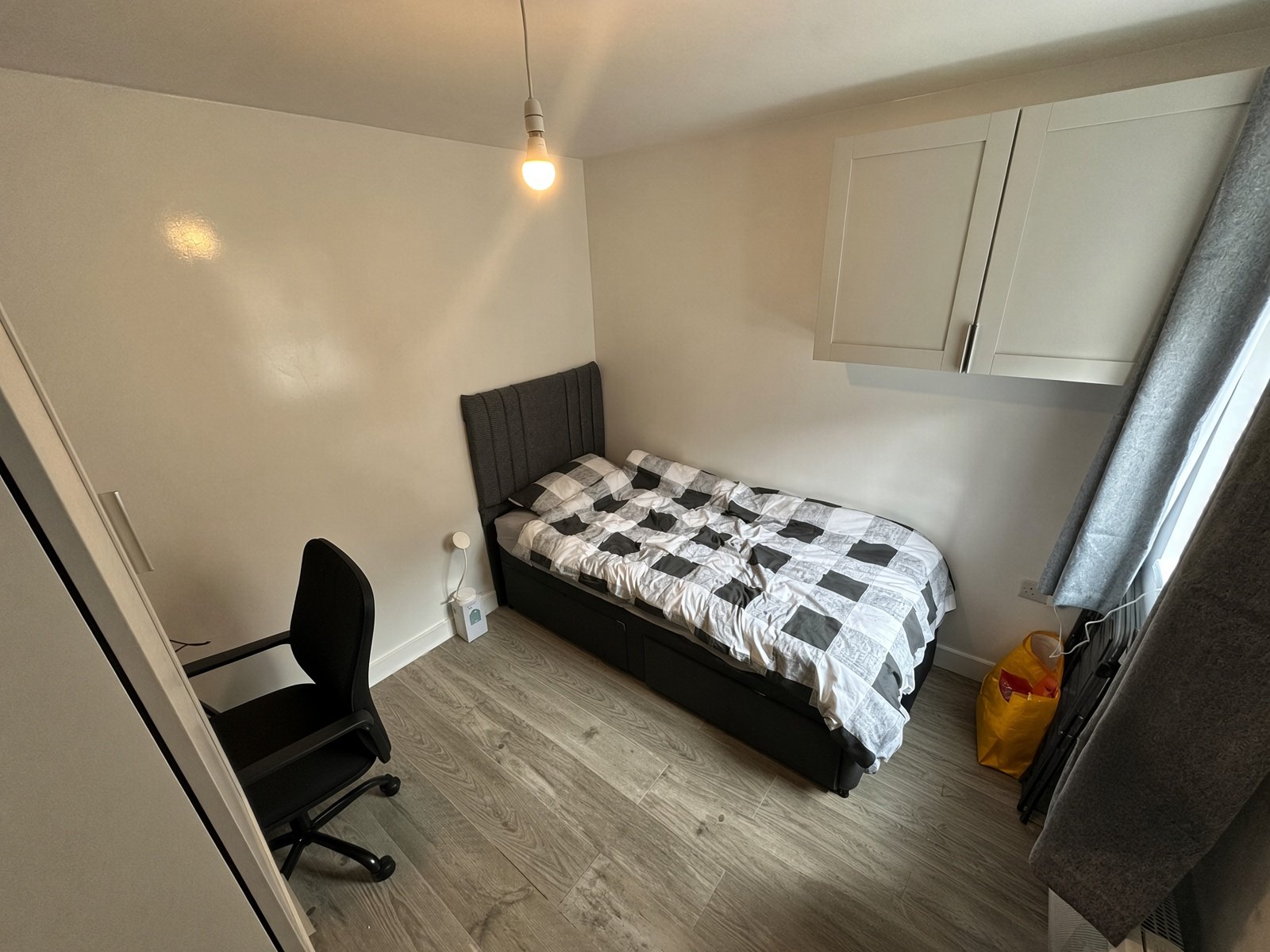 Bedroom with double bed, desk chair and wall cupboards