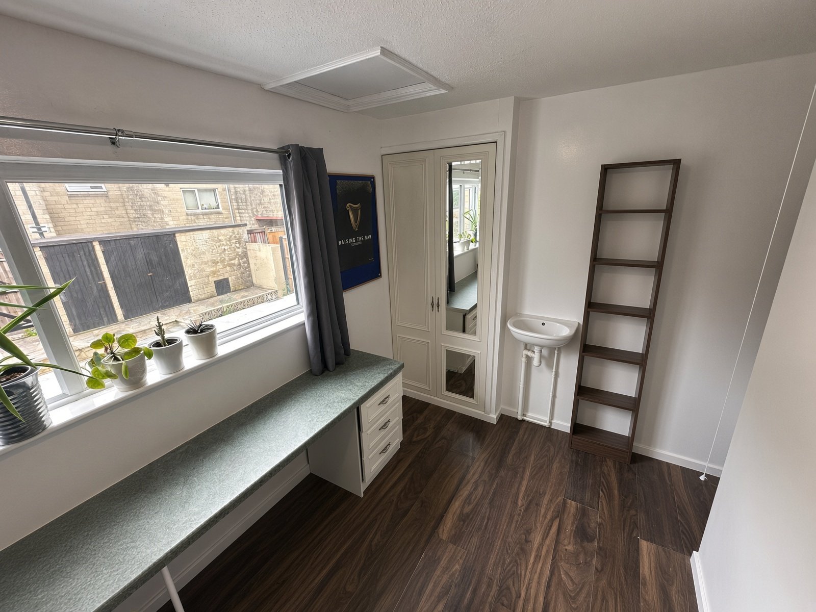 Bedroom with long window desk, basin and ladder shelf