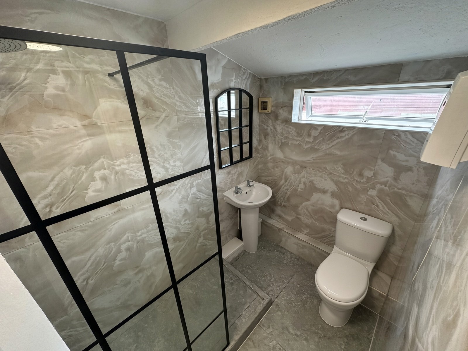 Bathroom with black-framed shower screen, basin and WC