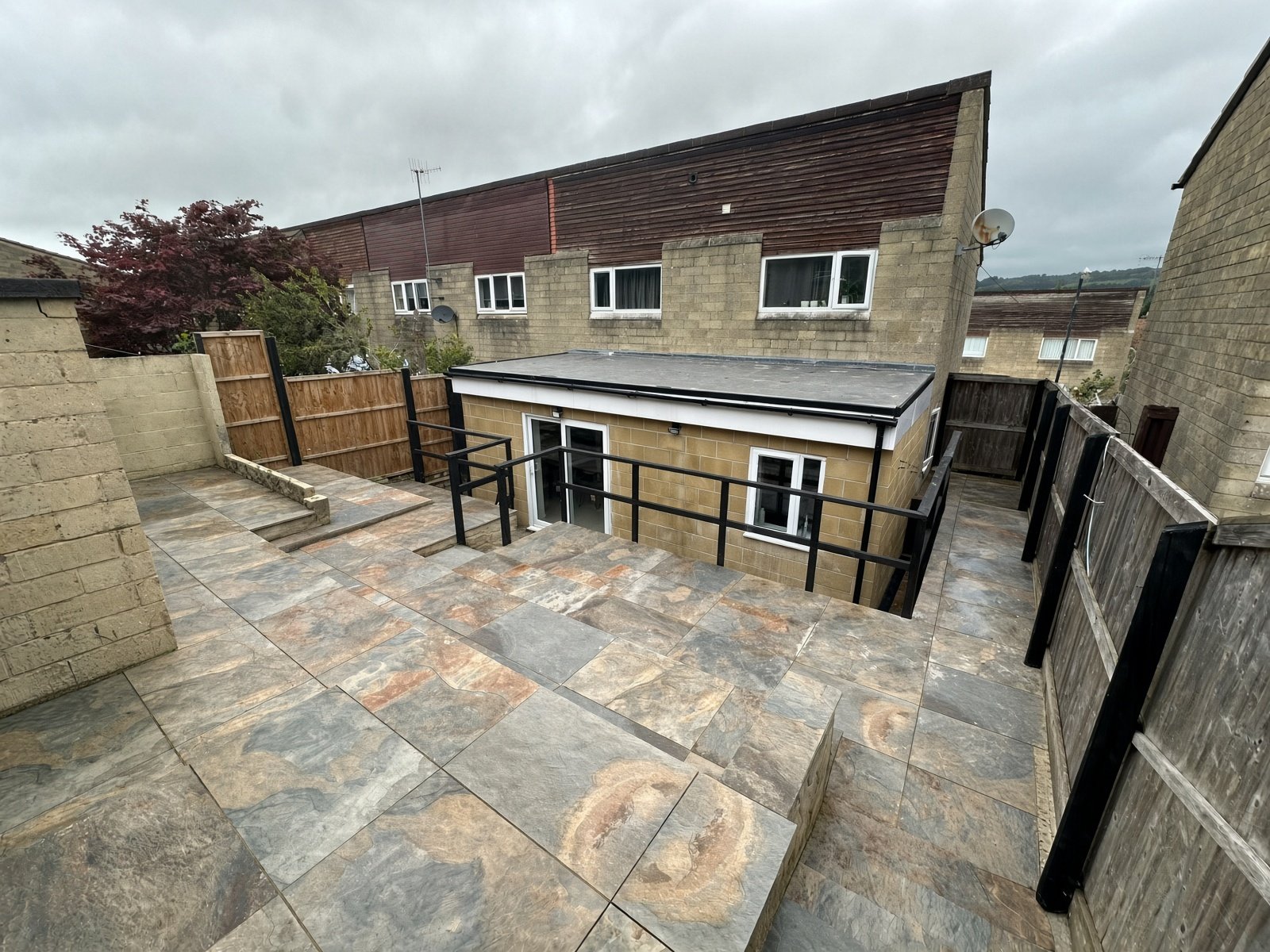 Rear garden patio with railings and steps up to the house