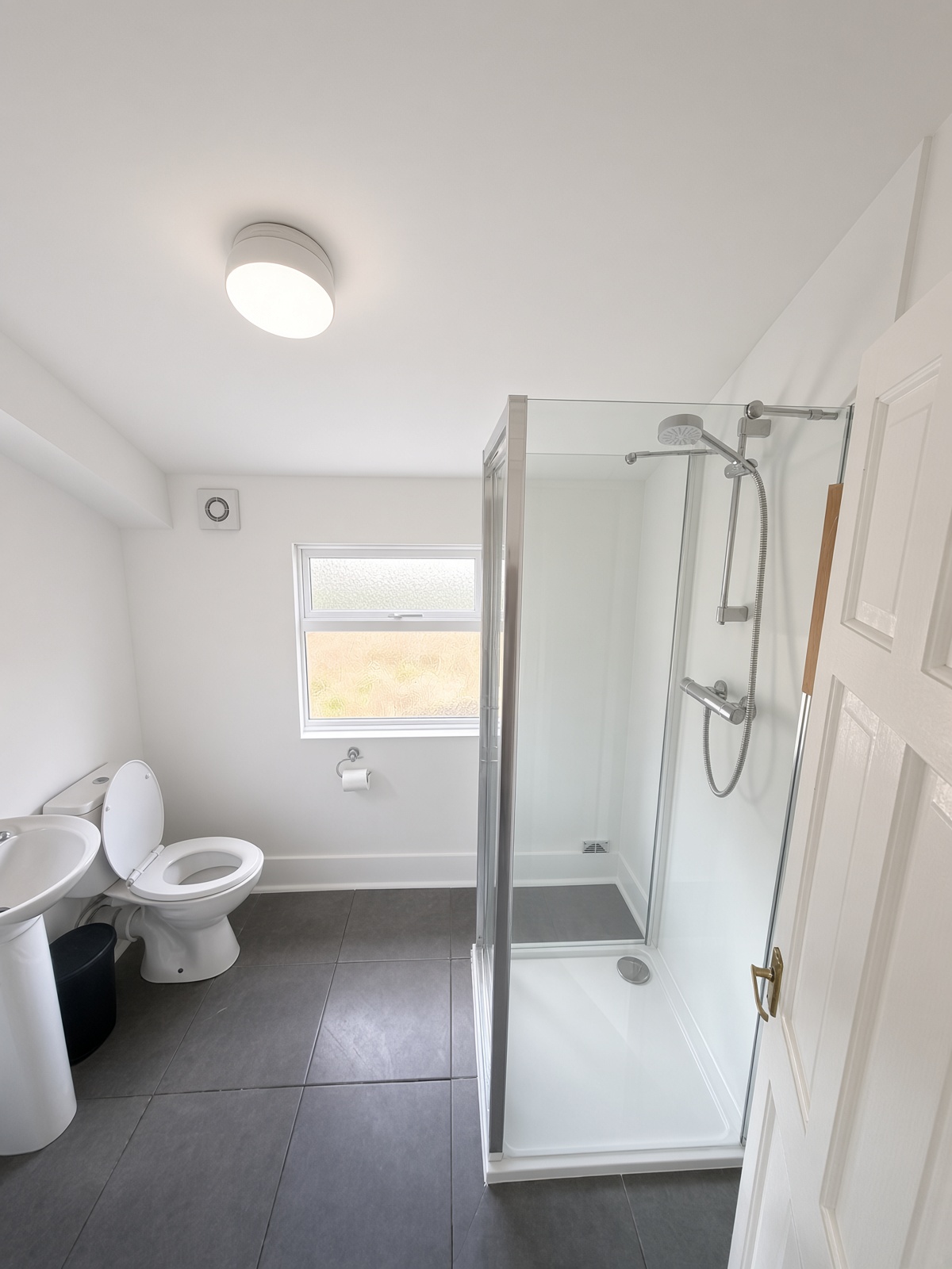 Bathroom with a glass shower cubicle, toilet, and basin