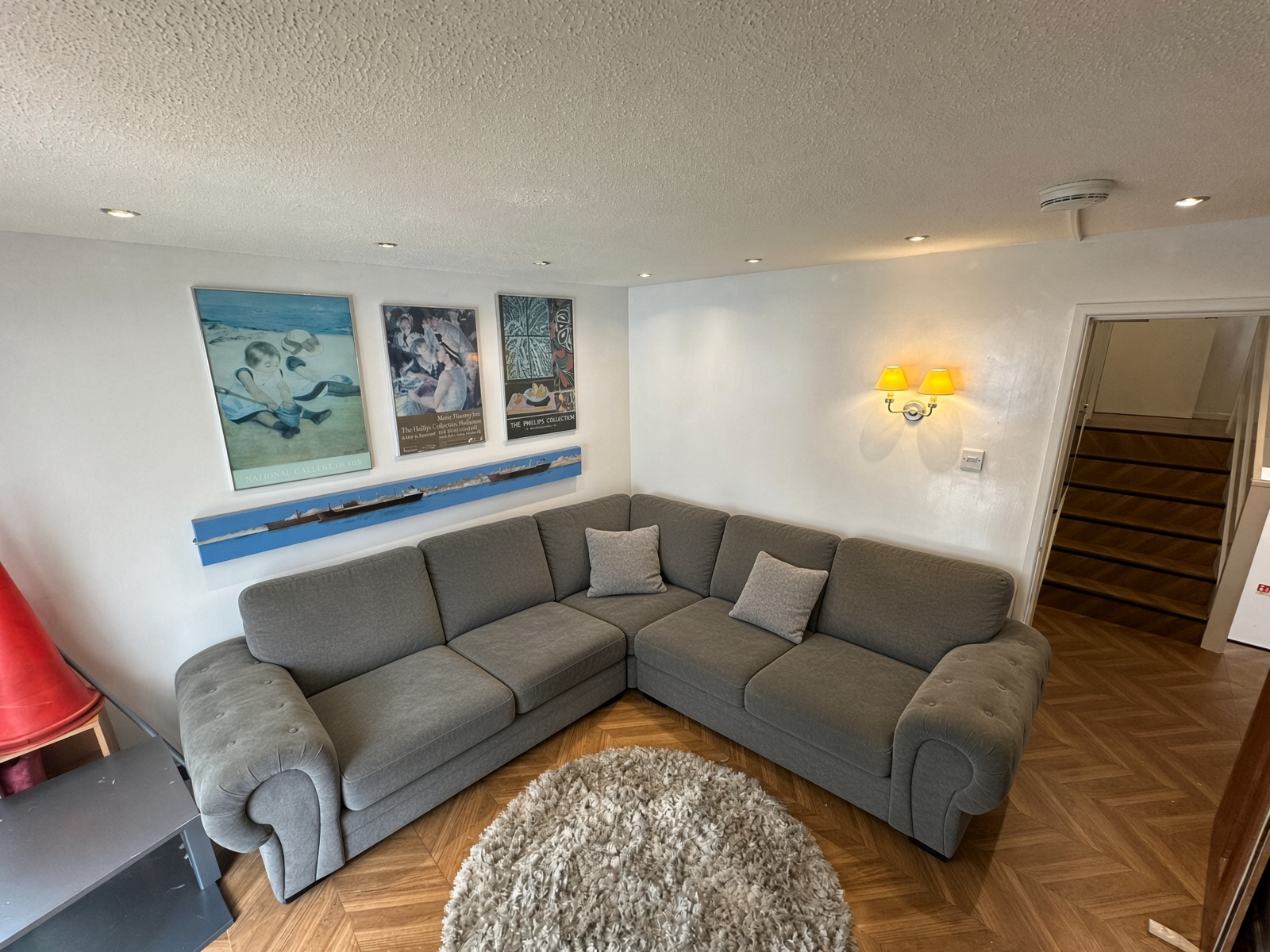 Living room with a grey corner sofa and herringbone flooring