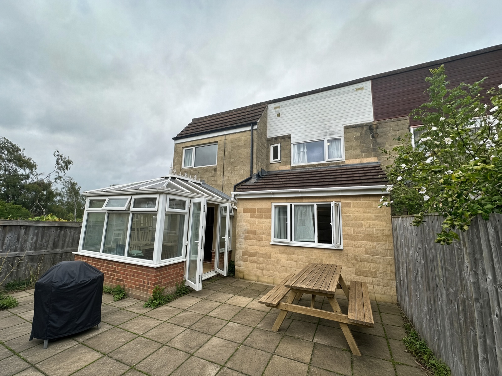 Rear patio with a picnic table and the conservatory