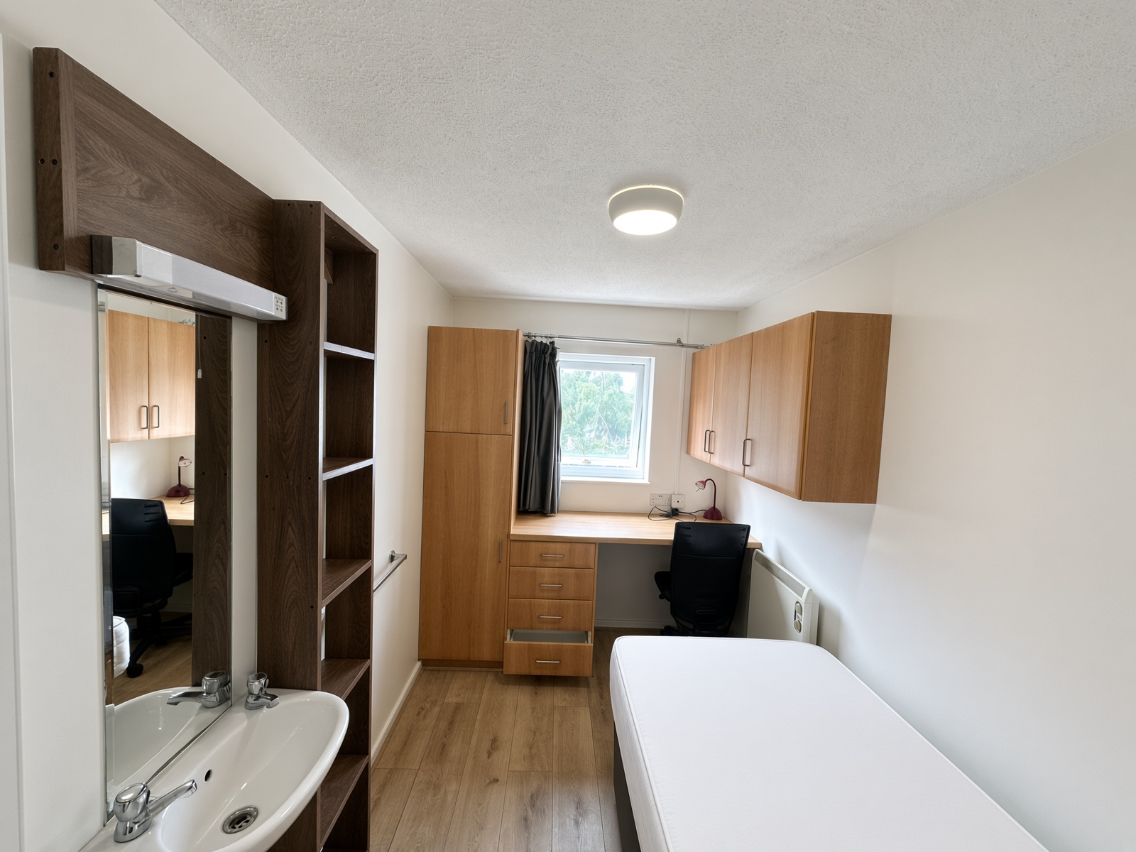 Bedroom looking from the washbasin toward a desk under the window