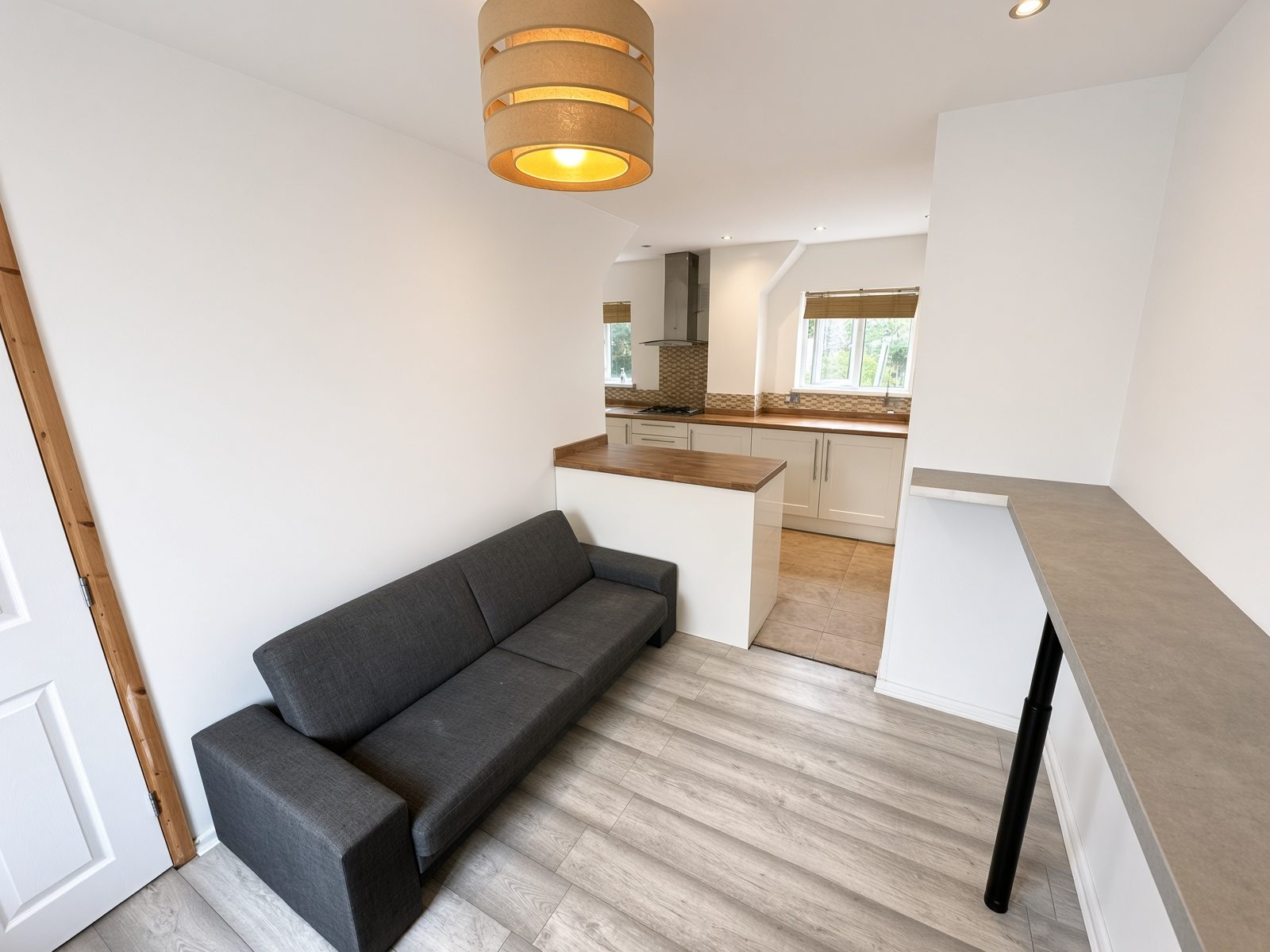 Living room with a grey sofa looking through to the kitchen