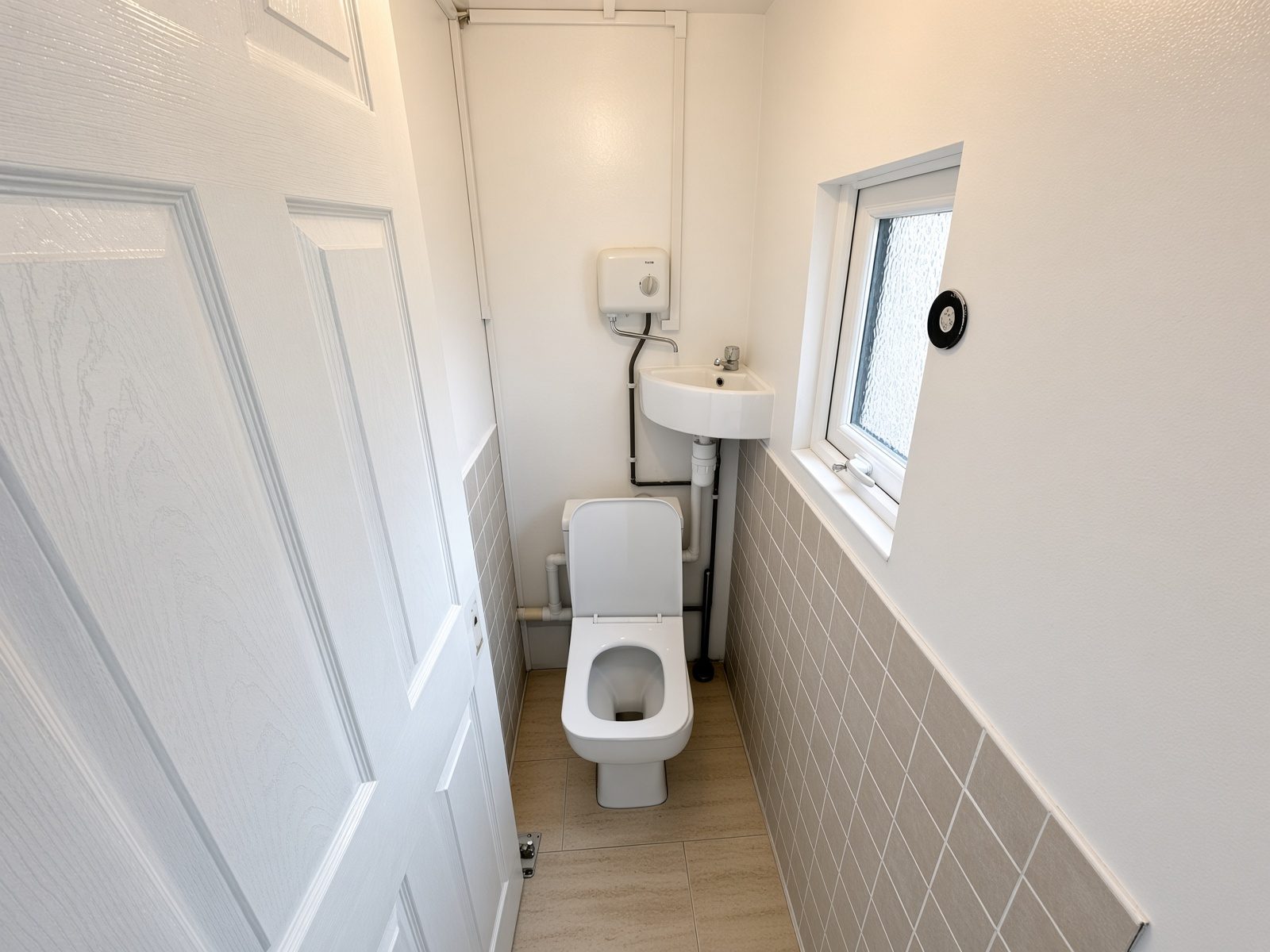 Cloakroom with a toilet, corner basin, and small window
