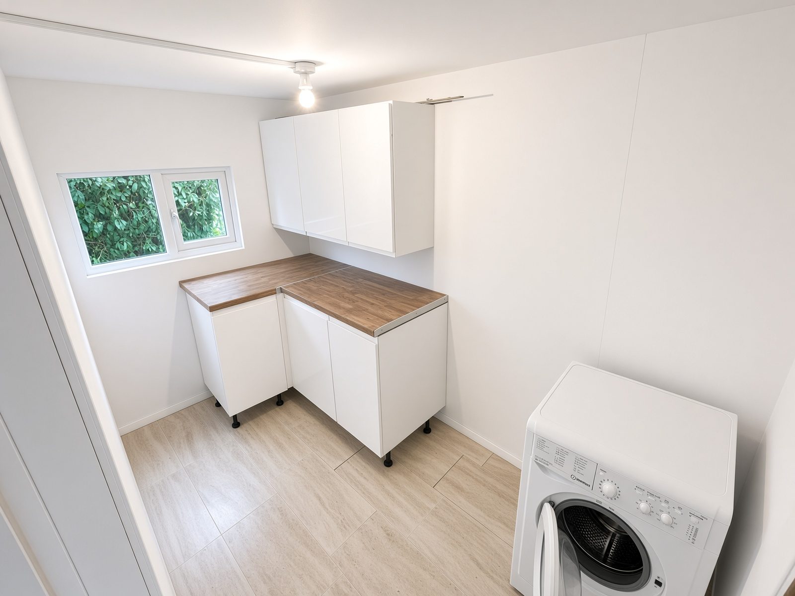 Utility room with white cabinets, a wood worktop, and a washing machine