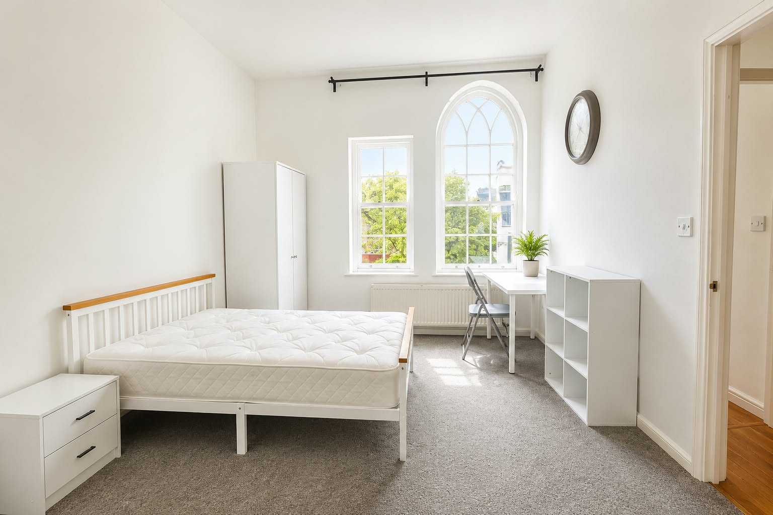 Bedroom 1 with a white double bed, desk, and arched sash windows