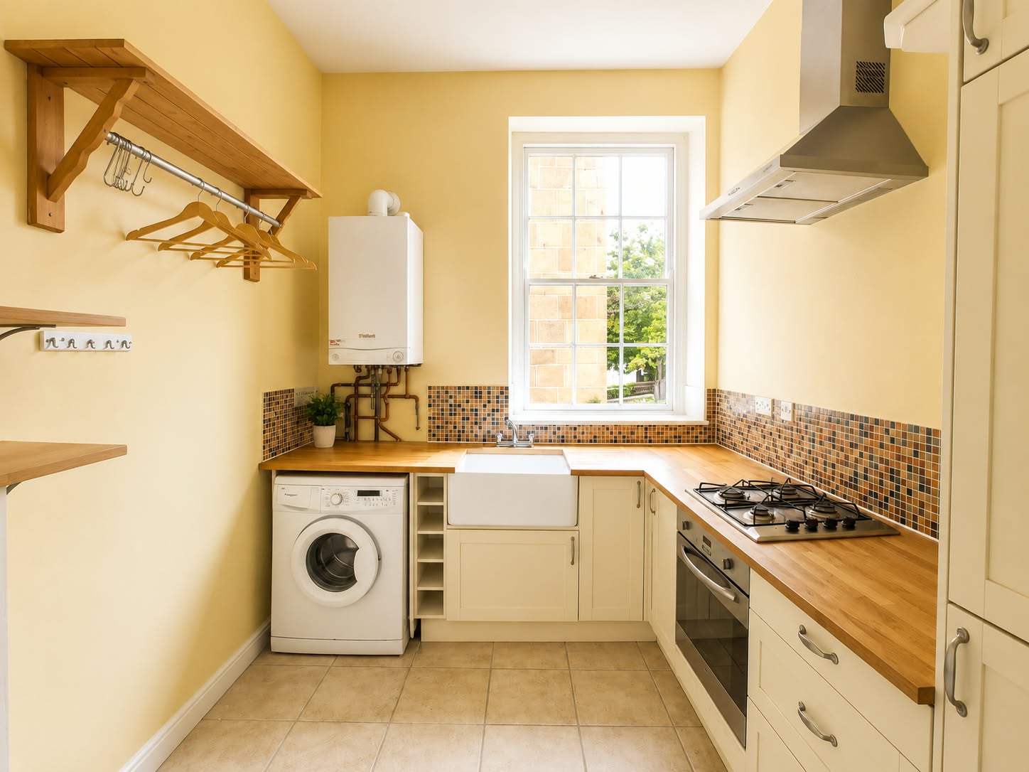 Kitchen with cream cabinets, wooden worktops, and a window over the sink